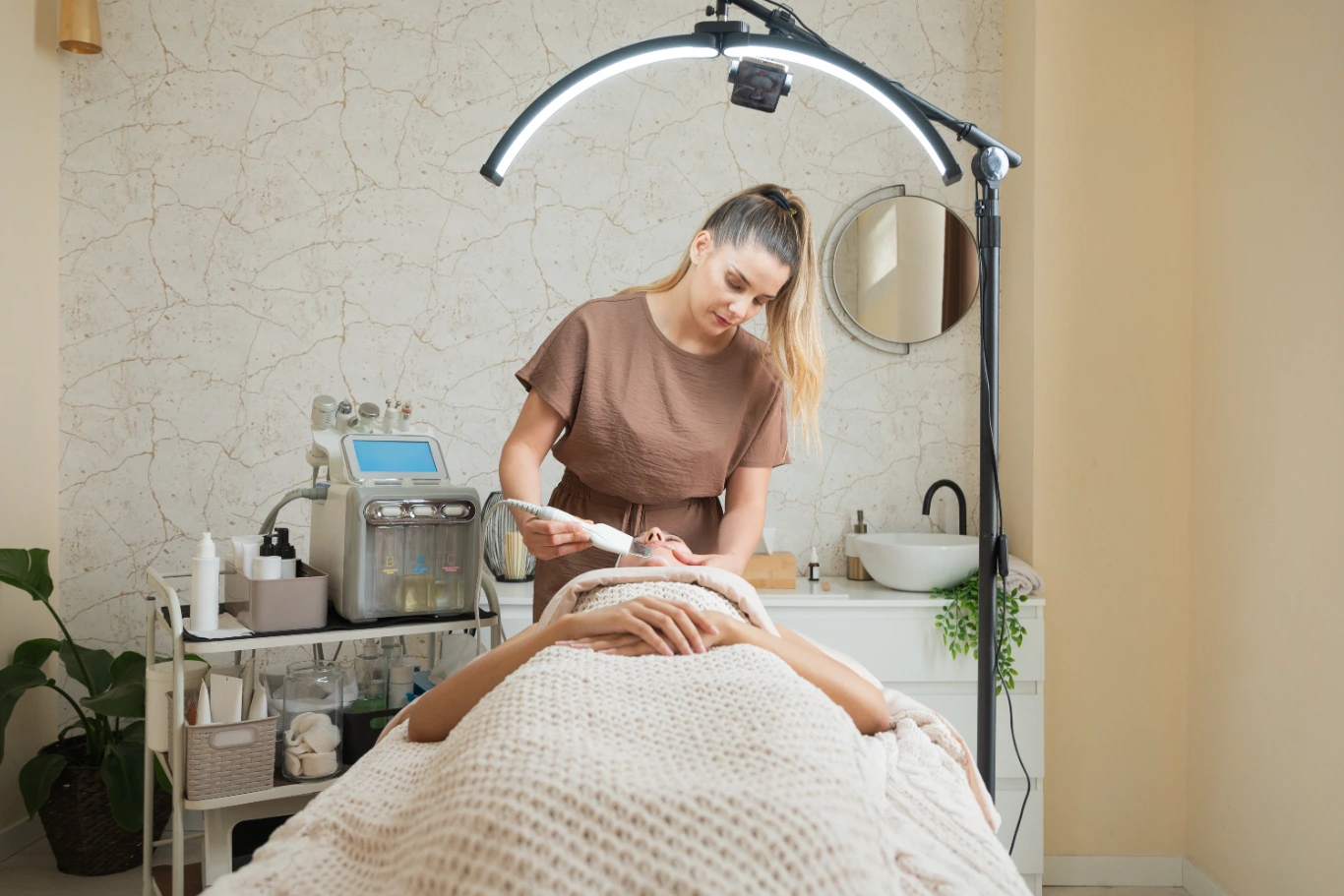Esthetician performing facial treatment in spa setting.